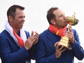 Sergio Garcia (right) kisses the trophy as Paul Casey looks on as they celebrate winning the 42nd Ryder Cup at Le Golf National Course at Saint-Quentin-en-Yvelines, France on September 30, 2018. (FRANCK FIFE/AFP/Getty Images)