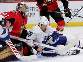 Rich Clune (R) is upended in front of Craig Anderson in period two as the Ottawa Senators face the Toronto Maple Leafs at the Canadian Tire Centre in Pre-season NHL action.