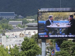 A TV screen shows a photo of South Korean President Moon Jae-in and North Korean leader Kim Jong UN, right, to advertise upcoming Seoul Defense Dialogue in Seoul, South Korea, Wednesday, Sept. 5, 2018.