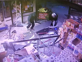 Suspects drag an ATM from a store in the town of Erin, Ont., in a photo of a security monitor video recorded on Thursday, Sept. 27, 2018.