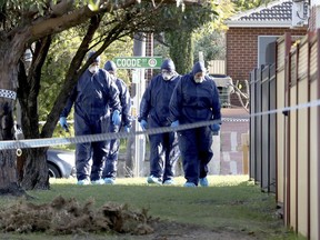 In this Sunday, Sept. 9, 2018 photo, forensic police officers inspect a property in suburban Perth, Australia. Three children, their mother and grandmother have been found dead in a house after a man alerted police, detectives said Monday.