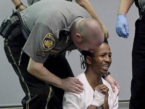 Shyhiem Adams is aided by a court marshal after collapsing as friends of the Justin Brady were screaming at Adams during his arraignment in Enfield Superior Court Tuesday, Sept. 11, 2018, in Enfield, Conn. (Jim Michaud/Journal Inquirer via AP, Pool)