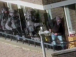 In this image made from video provided by the Netherlands Police, armed police prepare for an operation in a residential area in Arnhem, Netherlands, Thursday, Sept. 27, 2018. (Netherlands Police via AP)
