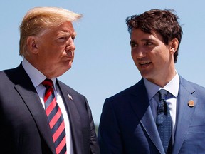 In this June 8, 2018, file photo, U.S. President Donald Trump talks with Prime Minister Justin Trudeau during a G7 Summit welcome ceremony in Charlevoix, Que.