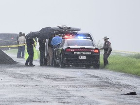 Law enforcement officers gather near the scene where the body of a woman was found near Interstate 35 north of Laredo, Texas on Saturday, Sept. 15, 2018. A U.S. Border Patrol agent suspected of killing four women was arrested early Saturday after a fifth woman who had been abducted managed to escape from him and notify authorities, law enforcement officials said, describing the agent as a "serial killer."