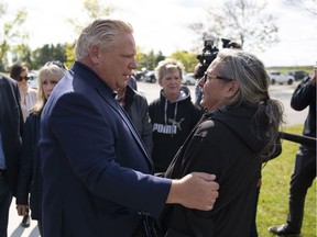 Premier Doug Ford embraces Colette Plante after arriving at West Carleton High School, an emergency shelter for residents affected by a tornado, in Dunrobin, Ont.