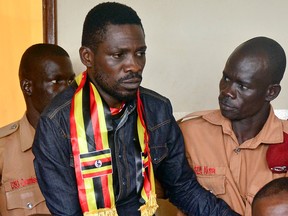 In this Thursday, Aug. 23, 2018 file photo, Ugandan pop star-turned-lawmaker Kyagulanyi Ssentamu, also known as Bobi Wine, centre, arrives at a magistrate's court in Gulu, northern Uganda.