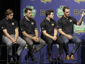 Chicago Blackhawks' Jonathan Toews, right, speaks as teammate Alex DeBrincat, second from right, and Boston Bruins' Charlie McAvoy, left, and Patrice Bergeron listen during a news conference Thursday, Sept. 6, 2018, in Chicago about the NHL Winter Classic hockey game.