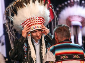 Prime Minister Justin Trudeau is presented a headdress in an honouring ceremony at the Tsuut'ina Nation near Calgary, Ab., on Friday March 4, 2016. Mike Drew/Postmedia