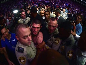 Khabib Nurmagomedov of Russia is escorted out of the arena after defeating Conor McGregor of Ireland in their UFC lightweight championship bout during the UFC 229 event inside T-Mobile Arena on October 6, 2018 in Las Vegas, Nevada.
