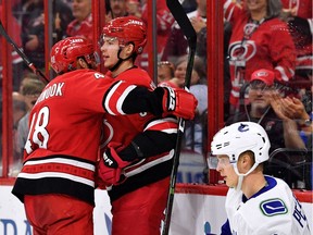 Andrei Svechnikov of the Carolina Hurricanes is hugged by teammate Jordan Martinook after scoring a goal against the Vancouver Canucks.