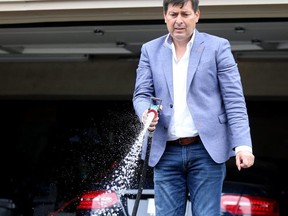 Etobicoke Centre (ward 2) candidate Angelo Carnevale is pictured washing off his driveway after vandals egged his house. (Dave Abel, Toronto Sun)