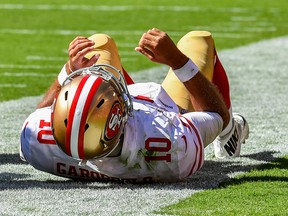 Jimmy Garoppolo of the San Francisco 49ers lays on his back on the sideline after being injured on the play during the fourth quarter of the game against the Kansas City Chiefs at Arrowhead Stadium on Sept. 23, 2018 in Kansas City, Mo.