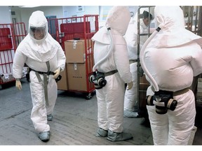 US Defense Department personnel, wearing protective suits, screen mail as it arrives at a facility near the Pentagon in Washington, DC on October 2, 2018. - US police on Wednesday arrested a suspect after suspicious packages containing castor seeds -- from which deadly ricin can be derived -- were sent to the Pentagon this week, US media reported. William Clyde Allen, of Logan, Utah, was in custody and would likely face charges by Friday, KSL TV reported on its website, citing the Justice Department.