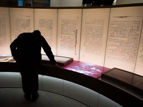 In this file photo taken on November 14, 2017, visitors look at an exhibit about the Dead Sea scrolls during a media preview of the new Museum of the Bible,  a 430,000 square-foot museum, dedicated to the history, narrative and impact of the Bible, in Washington, D.C. (SAUL LOEB / AFP)SAUL LOEB/AFP/Getty Images