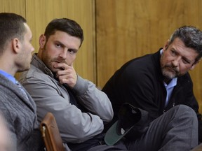 FILE - In this Oct 3, 2018, file photo, Track Palin, center, and his father Todd Palin, right, talk with an unidentified man before his change of plea hearing in Veterans Court at the Boney Courthouse in Anchorage, Alaska. The oldest son of Alaska Gov. Sarah Palin has won a postponement on starting a year in custody in an assault case after his lawyer said a bed at a treatment hospital for veterans became available.  Track Palin was supposed to turn himself in to an Anchorage halfway house Wednesday, Oct. 31, 2018, after a judge decided new assault allegations disqualified him from a veterans therapeutic court program.
