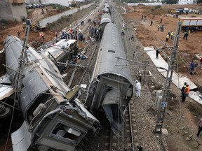 People gather after train derailed Tuesday Oct.16, 2018 near Sidi Bouknadel, Morocco. A shuttle train linking the Moroccan capital Rabat to a town further north on the Atlantic coast derailed Tuesday, killing several people and injuring dozens, Moroccan authorities and the state news agency said.