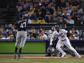 Milwaukee Brewers starting pitcher Gio Gonzalez twists his ankle going for a ball hit by Los Angeles Dodgers' Yasiel Puig during Game 4 of the National League Championship Series Tuesday, Oct. 16, 2018, in Los Angeles.