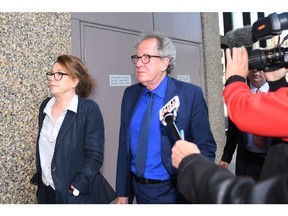 Australian actor Geoffrey Rush, center, leaves the Federal Court in Sydney, Australia Monday, Oct. 22, 2018. The actor faced a large media pack Monday as he entered Sydney's Federal Court, where a judge is hearing his defamation trial against Sydney's Daily Telegraph and its journalist Jonathon Moran. (Dean Lewins/AAP Image via AP) ORG XMIT: TKMY801