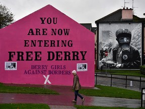 A woman walks past a mural that states 'Derry Girls Against Borders' at Free Derry Corner on October 9, 2018 in Derry, Northern Ireland. (Charles McQuillan/Getty Images)
