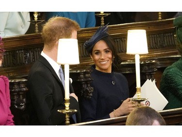 Prince Harry and Meghan, Duchess of Sussex take their seats ahead of the wedding of Princess Eugenie of York and Jack Brooksbank in St George's Chapel, Windsor Castle, near London, England, Friday Oct. 12, 2018. (Danny Lawson/Pool via AP) ORG XMIT: RWW326