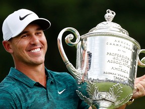 In this Aug. 12, 2018, file photo, Brooks Koepka holds the Wanamaker Trophy after he won the PGA Championship golf tournament at Bellerive Country Club, in St. Louis.