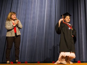 Janaya Chekowski-McKenzie , 8, with terminal brain cancer gets her bucket list wish to graduate high school at M.E. LaZerte on Wednesday, Oct. 10, 2018 in Edmonton. Michelle Draper, Edmonton Public Schools chairwoman, watches Jamaya as she walks across the stage after receiving her diploma.