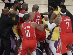 Houston Rockets' Chris Paul, second from left, is held back by Los Angeles Lakers' LeBron James, left, as Paul fights with Lakers' Rajon Rondo, center obscured, during the second half of an NBA basketball game Saturday, Oct. 20, 2018, in Los Angeles. (AP Photo/Marcio Jose Sanchez)