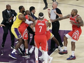 Houston Rockets' Chris Paul, second from left, is held back by Los Angeles Lakers' LeBron James, left, as Paul fights with Lakers' Rajon Rondo, center obscured, during the second half of an NBA basketball game Saturday, Oct. 20, 2018, in Los Angeles. The Rockets won, 124-115.