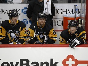 Pittsburgh Penguins' Sidney Crosby (87), Phil Kessel (81), and Evgeni Malkin (71) sit on the bench during the third period of an NHL hockey game against the Montreal Canadiens in Pittsburgh, Saturday, Oct. 6, 2018. (AP Photo/Gene J. Puskar)