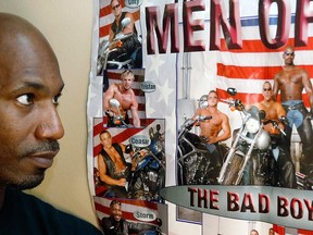 Former male dancer David Crosby, left, looks at a poster showing Cesar Sayoc, second from bottom and at right on motorcycle next to Crosby, Saturday, Oct. 27, 2018, in Hopkins, Minn.