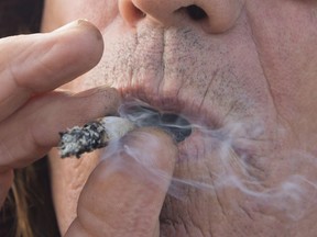 A man smokes a marijuana joint in Kamloops, B.C. Wednesday, Oct. 17, 2018.