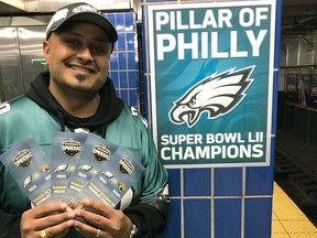 In this October 2018 photo provided by Matt Liston, Philadelphia Eagles fan Jigar Desai poses with tickets to an Oct. 28 football game between the Eagles and the Jacksonville Jaguars in front of the subway pillar he ran into earlier this year at Ellsworth Station on the Broad Street subway line in Philadelphia. (Matt Liston via AP)