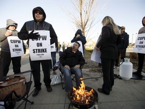 Canada Post workers picket after going on strike in Edmonton, on Monday, Oct. 22, 2018.