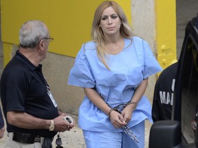 In this Sept. 24, 2015 photo, Aurea Vazquez Rijos, who was accused more than a decade ago of the murder of her husband, the Canadian Adam Anhang, is taken to the Federal Court in Hato Rey, Puerto Rico. (Carlos Giusti/El Vocero via AP, File)