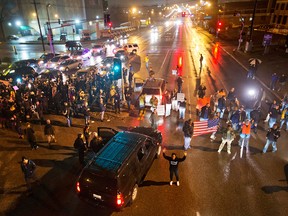 Demonstrators block a busy intersection while marching through the streets to protest the August shooting of Michael Brown, Sunday, Nov. 23, 2014, in St. Louis.