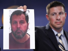 Timothy Wiley, FBI public affairs specialist, holds a photo of Amor Ftouhi after a news conference in Detroit, June 22, 2017.