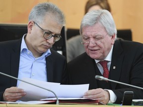 The March 21, 2018 photo shows Hesse governor Volker Pouffier, right, of the Christian Democratic Party CDU and Hesse Economy Minister Tarek Al-Wazir of the Green party talking in the Landtag state parliament of Hesse in Wiesbaden, western Germany. The stakes are unusually high for German Chancellor Angela Merkel's government as the central region of Hesse votes in a state election this weekend.