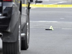 A gun lies on the ground next to an evidence marker outside of a Kroger Grocery in Jeffersontown, Ky., Wednesday, Oct. 24, 2018,. The shooting left two people dead, and the subject in custody.