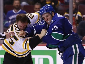 Boston Bruins' Noel Acciari fights Vancouver Canucks' Bo Horvat  during second period NHL hockey action in Vancouver on Saturday, Oct. 20, 2018.