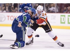 Vancouver Canucks defenseman Erik Gudbranson (44) fights with Calgary Flames defenseman Travis Hamonic (24) during first period NHL action at Rogers Arena in Vancouver, Wednesday, Oct, 3, 2018.