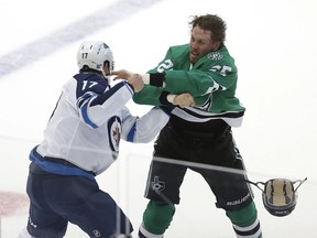 Dallas Stars forward Brett Ritchie (25) and Winnipeg Jets forward Adam Lowry (17) fight during the first period of an NHL hockey game, Saturday, Oct. 6, 2018, in Dallas.