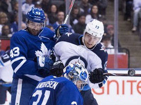 Toronto Maple Leafs goaltender Frederik Andersen makes a save against a tip from Winnipeg Jets left wing Brandon Tanev as Maple Leafs centre Nazem Kadri looks on Saturday night.