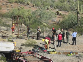 This Oct. 17, 2018 photo provided by the Maricopa County Sheriff's Office shows a rescue team gathers to rescue a man who fell into an old abandoned mine shaft near Aguila, Ariz. A hospital spokeswoman said the man who fell into the old abandoned mine shaft is in good condition awaiting surgery for two broken legs. Sheriff's officials say the man fell into the shaft Monday, Oct. 15, 2018, and was found two days later by someone who heard his calls for help. (Maricopa County Sheriff's Office via AP)
