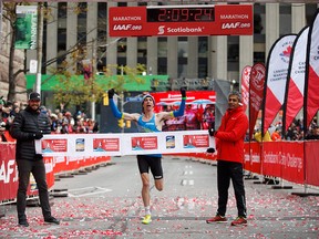 Canadian Cam Levins reacts as he crosses the finish line of the Toronto Scotiabank Waterfront Marathon in Toronto on Sunday, Oct. 21, 2018.