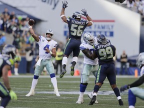 In this Sept. 23, 2018, file photo, Seattle Seahawks linebacker Mychal Kendricks (56) leaps as Dallas Cowboys quarterback Dak Prescott (4) attempts a pass during the second half of an NFLgame in Seattle. The Cowboys, who can't find anything remotely resembling a rhythm with quarterback Dak Prescott and a new group of receivers, are at home this week against the Detroit Lions.