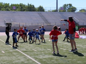 Detroit Lions tight end Luke Willson (right) coaches students during a flag football play at London's Jumpstart Games. The games provide kids the opportunity to learn new skills and have fun while being active.