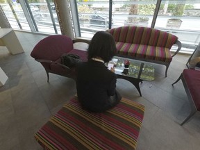 Grace Meng, the wife of missing Interpol President Meng Hongwei, who does not want her face shown, consults her mobile phone in the lobby of a hotel in Lyon, central France, where the police agency is based, on Sunday Oct. 7, 2018.