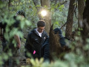 In this Monday, Oct. 22, 2018 photo, detectives investigate the scene where remains believed to be those of a southwestern Michigan woman who disappeared in 2010 were found, in Fulton, Mich. Doug Stewart, who was convicted of killing his estranged wife in 2011, took police to the burial site Monday.