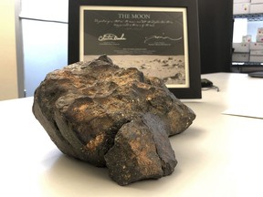 A 12-pound (5.5 kilogram) lunar meteorite discovered in Northwest Africa in 2017 rests on a table, in Amherst, N.H. The rock, which is actually comprised of six fragments that fit together like a puzzle, was found last year in a remote area of Mauritania, but may have plunged to Earth thousands of years ago. The meteorite could sell for $500,000 or more at an online auction that runs from Thursday, Oct. 11, until Oct. 18, 2018.